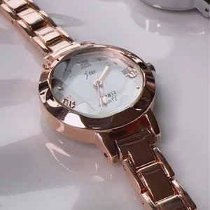 Close-up of rose gold quartz watch featuring Roman numeral indices and sleek metal band