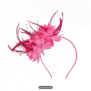 Macro shot of rose red bridal fascinator with elegant feathers, fabric flowers and beads