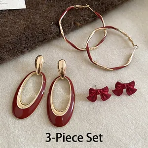Three-piece set featuring deep red and gold enamel fishtail and bow-knot earrings