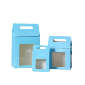 Three blue kraft paper gift boxes with handles and clear windows in varying sizes