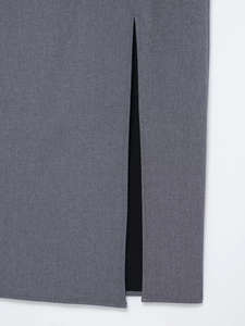 Détail d'une robe grise avec fente latérale montrant la texture fine du tissu