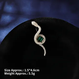 Detailed view of silver snake brooch with green emerald-cut stone, size 1.5x4.6cm