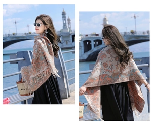 Close-up of ethnic paisley scarf with fringes on beige base for winter styling