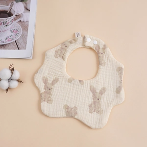 Detail of petal-shaped muslin baby bib with rabbit print and secure snap button