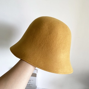 Gros plan détaillé montrant la texture en feutre de laine et les coutures du chapeau jaune
