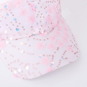 Close-up of pink mesh cap with floral patterns and iridescent sequins on the brim