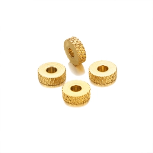 Macro view of four 6mm golden checkered wheel spacers for DIY jewelry craft