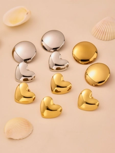 Close-up of polished gold and silver heart and circle geometric stud earrings for women
