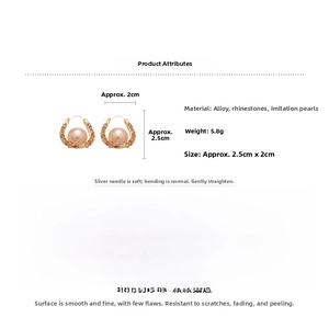 Macro detail of French style U-shaped gold earrings with pearls and crystals