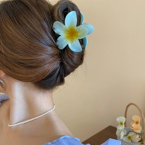 Detail showing the blue acrylic gradient lily flower hair claw clip on back of hair