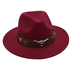 Detail of burgundy fedora hat with brown leather band and silver bull head metal emblem