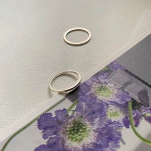 Minimalist 925 sterling silver square band rings set on a light grey textured background