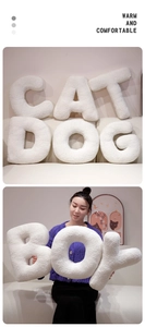Detail of soft white plush letter pillows in boucle fabric for home and nursery decor