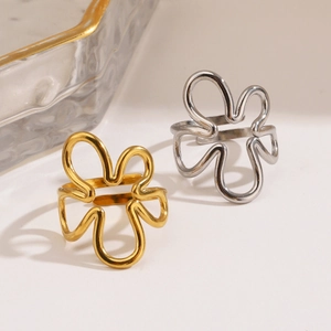 Bagues fleurs évidées en or et argent présentées sur un fond minimaliste élégant