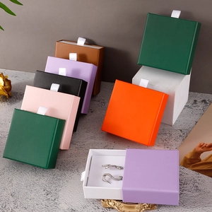 Colorful drawer jewelry boxes in green, pink and purple with white ribbon handles