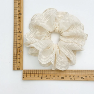 Chouchou en dentelle blanc cassé avec bord fleuri, diamètre 12cm sur fond blanc