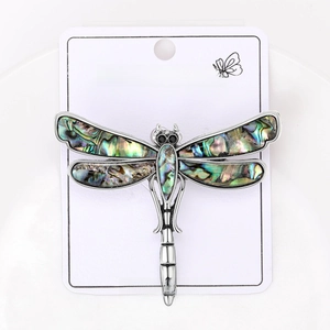 Detailed macro view of vintage dragonfly brooch with abalone shell wings and crystal accents