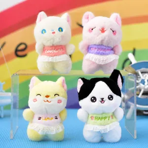 Close-up of four cute plush cat toys with colorful lace dresses and embroidered words