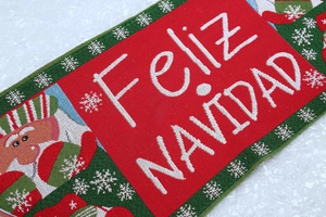Close-up of red and green knitted Christmas table runner with Feliz Navidad text