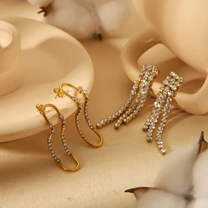 Elegant gold titanium steel U-shaped earrings with tassel diamonds on a ceramic dish
