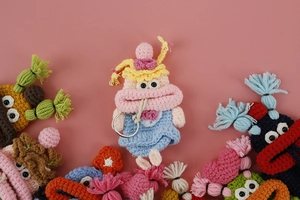 Close-up of handmade crochet sausage mouth key cases in assorted pastel colors