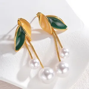 Golden earrings set with colorful leaves, tassel chains, and elegant white pearls