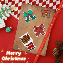 Close-up of cute Christmas themed stickers with Santa and bows on a craft envelope
