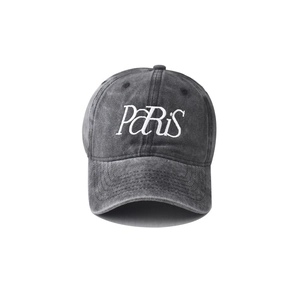 Dettaglio del cotone lavato vintage e del ricamo PARIS bianco sul cappellino da baseball