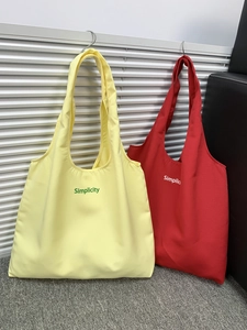 Detail of large canvas tote bags with Simplicity print in red and yellow colors