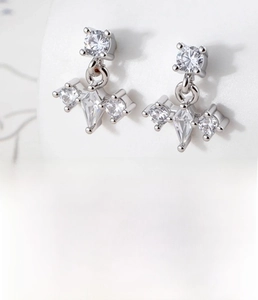 Macro shot of silver geometric titanium steel studs with zircon and dimensions chart