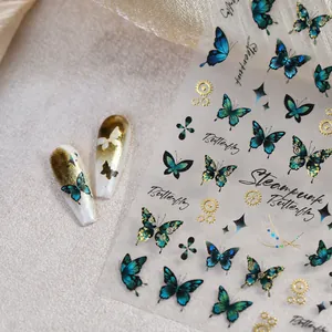Detail of steampunk butterfly nail art stickers with gold gears and cyan butterfly designs