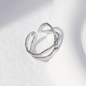 Detail of silver irregular open ring with hand-hammered texture on white stone