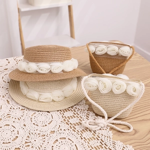 Zomerse ouder-kind strohoed en tassenset met crème rozen en kanten versieringen.