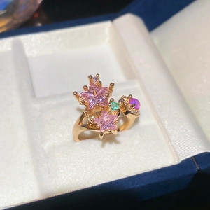 Macro view of gold star ring with pink star-shaped stones and opal-style gems