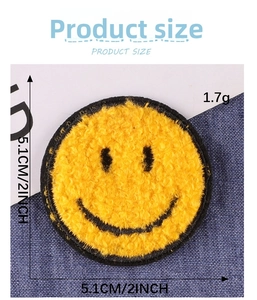 Detail of yellow chenille smiley patch showing 5.1cm diameter on denim background