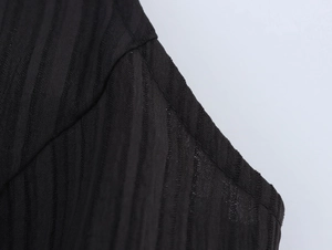 Gros plan d'une robe noire sans manches montrant le tissu en maille et les coutures d'épaule