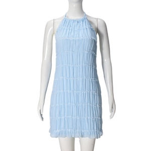 Detail of light blue backless dress featuring fine pleats and layered ruffle textures