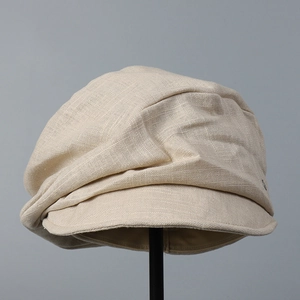 Detail shot of beige linen newspaper boy hat showing natural fabric texture and brim