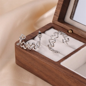 Minimalist silver stainless steel hoop earrings with hollow heart link design on silk