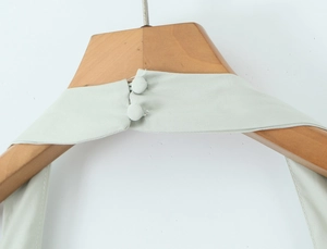Détail du décolleté dos nu vert menthe avec deux boutons recouverts de tissu assorti