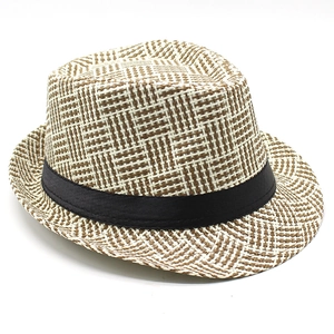 Macro detail of brown checkered woven straw fedora hat featuring black satin ribbon band