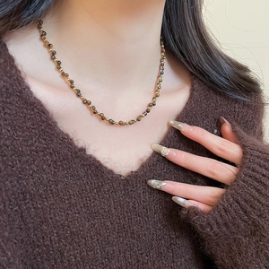 Dettaglio della collana occhio di tigre con perline in oro 18k indossata sul collo