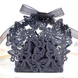 Detailed view of black laser-cut butterfly gift box with ribbon bow for wedding candy