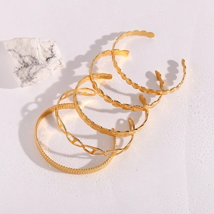Set of five adjustable gold stainless steel open bangles with woven and heart textures