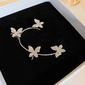 Detailed close-up of butterfly ear cuff with silver rhinestones on black velvet