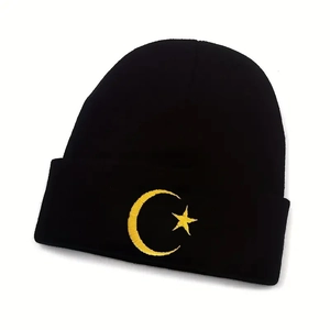 Close-up detail of moon and star embroidery on a black knitted winter beanie hat