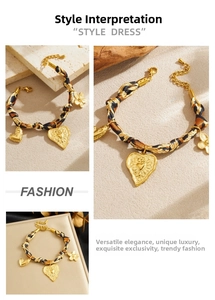 Dettaglio del bracciale con nastro leopardato e ciondoli a cuore e fiore placcati in oro