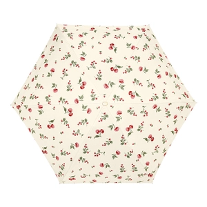 Flat lay of cream six-fold parasol with vintage red cherry print and sun protection coating