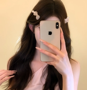 Close-up of elegant pearl bow hair clips on model's hair showing retro sweet style
