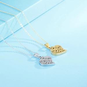 Detail of heart hollow pendants in gold and silver finish on blue textured cubes